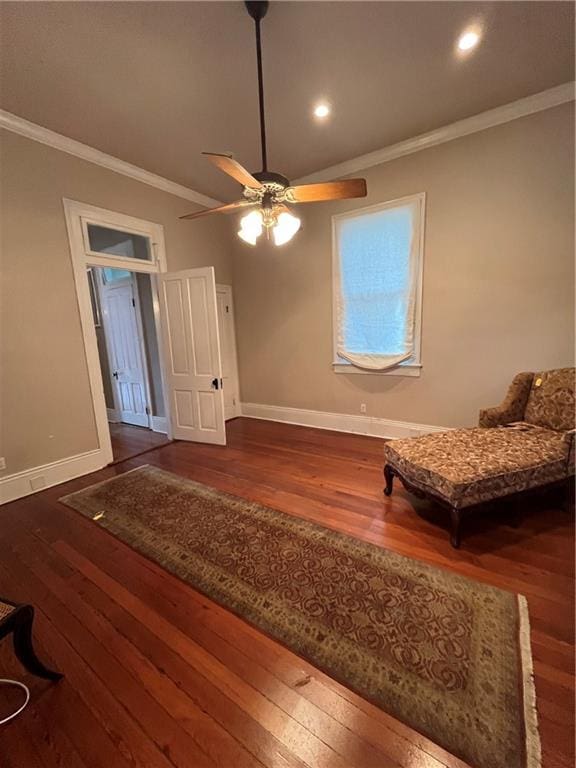 living area with crown molding, ceiling fan, and dark wood-type flooring