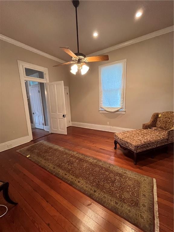 living area with crown molding, ceiling fan, and dark hardwood / wood-style floors