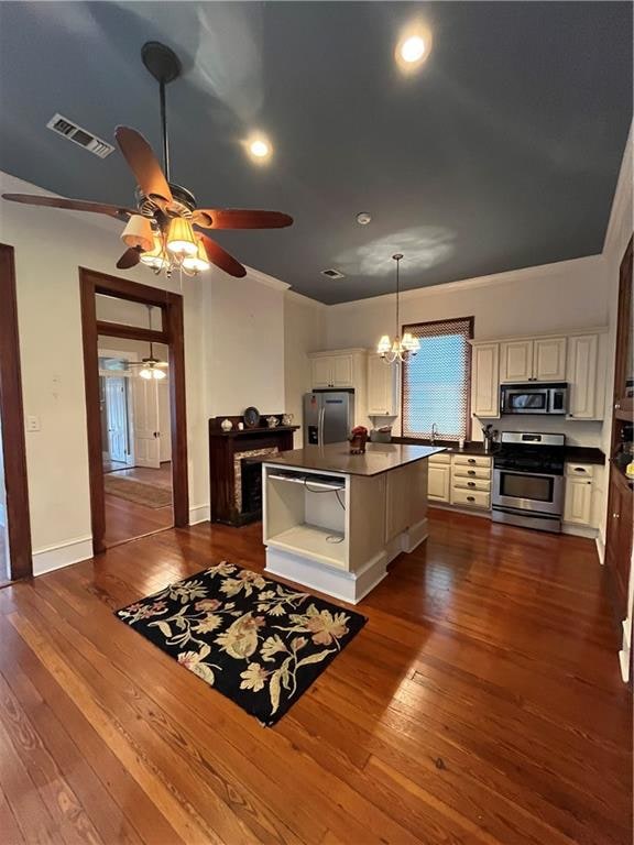 kitchen featuring sink, dark hardwood / wood-style floors, decorative light fixtures, a kitchen island, and stainless steel appliances