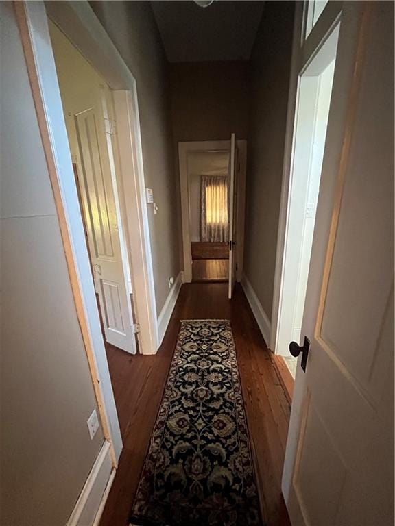 corridor with dark hardwood / wood-style flooring