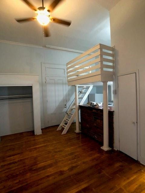 unfurnished bedroom featuring ornamental molding, dark wood-type flooring, and ceiling fan