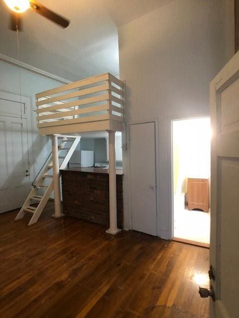 unfurnished bedroom with dark wood-type flooring and a high ceiling