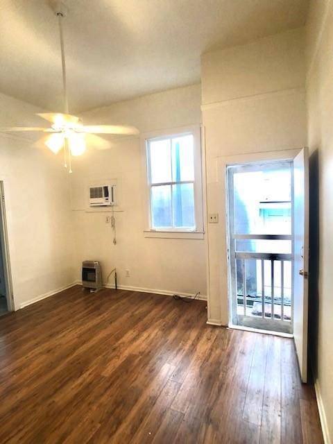 unfurnished room featuring heating unit, ceiling fan, dark hardwood / wood-style floors, and a wall unit AC