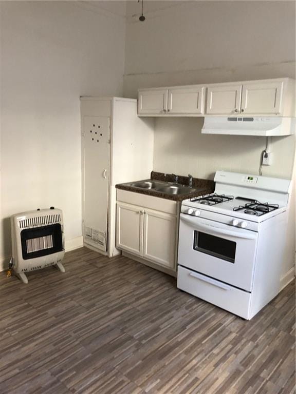 kitchen with sink, heating unit, white cabinets, and white gas range oven