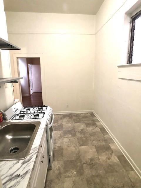 kitchen with white cabinetry, sink, range hood, and white gas range oven