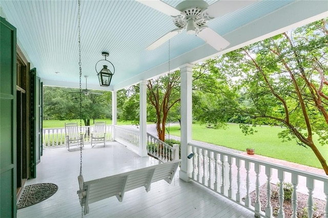 deck featuring ceiling fan and a lawn