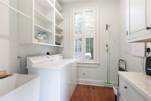 clothes washing area with sink, cabinets, a healthy amount of sunlight, and dark hardwood / wood-style floors