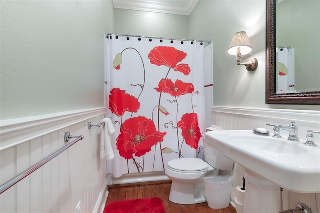 bathroom featuring crown molding, hardwood / wood-style flooring, and toilet