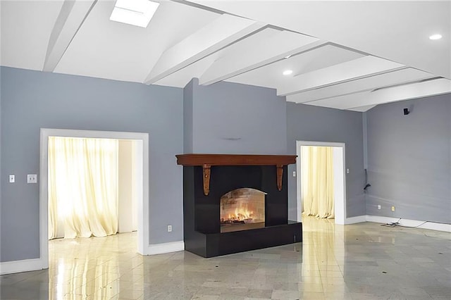 unfurnished living room with vaulted ceiling with skylight