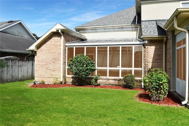 exterior space featuring a sunroom and a lawn