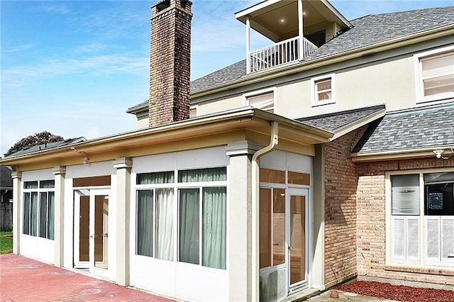 rear view of property with a sunroom and a patio area