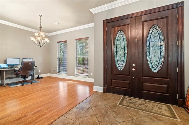 foyer featuring ornamental molding, a notable chandelier, and light tile patterned flooring