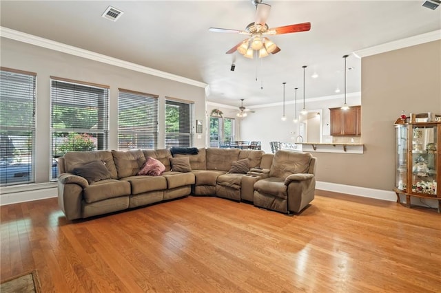 living room featuring light wood-type flooring, ceiling fan, and ornamental molding