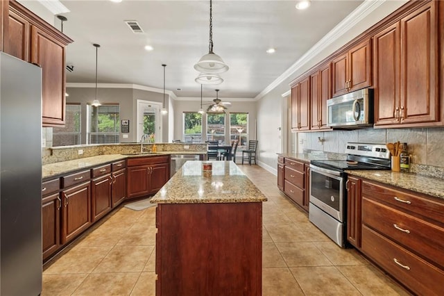 kitchen featuring light tile patterned flooring, stainless steel appliances, hanging light fixtures, sink, and kitchen peninsula