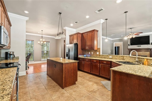 kitchen featuring light hardwood / wood-style flooring, stainless steel appliances, pendant lighting, ceiling fan with notable chandelier, and ornamental molding