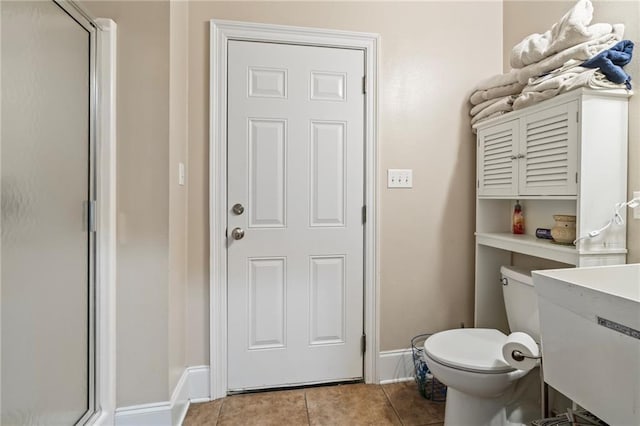 bathroom with a shower with shower door, vanity, tile patterned flooring, and toilet