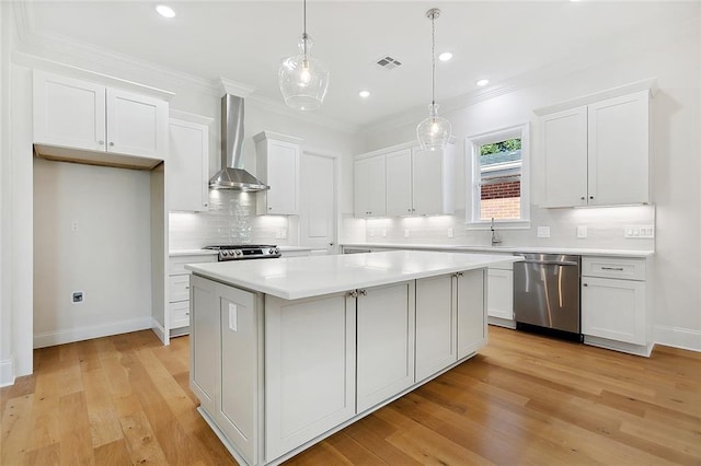 kitchen with wall chimney range hood, dishwasher, light hardwood / wood-style floors, backsplash, and a kitchen island