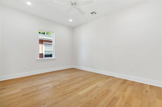 empty room with ceiling fan and light hardwood / wood-style floors