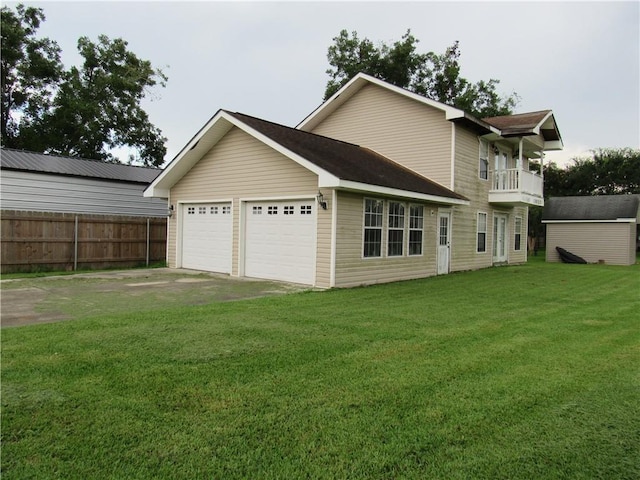 rear view of property featuring a balcony, a garage, and a lawn