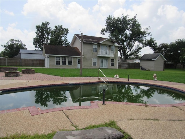 view of swimming pool with a yard, a patio area, and an outdoor fire pit