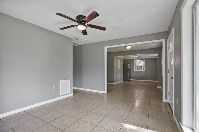 tiled spare room featuring ceiling fan