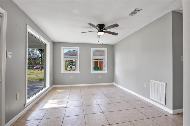 tiled empty room featuring ceiling fan and plenty of natural light