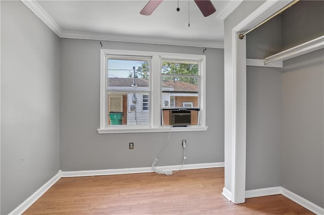 unfurnished bedroom with a closet, hardwood / wood-style flooring, ceiling fan, crown molding, and cooling unit