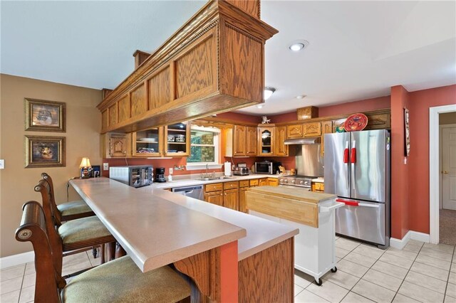 17 P M Hall Rd, Poplarville, MS 39470 - kitchen featuring kitchen peninsula, appliances with stainless steel finishes, light tile patterned floors, and sink