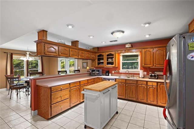 17 P M Hall Rd, Poplarville, MS 39470 - kitchen featuring light tile patterned flooring, kitchen peninsula, a kitchen island, appliances with stainless steel finishes, and sink