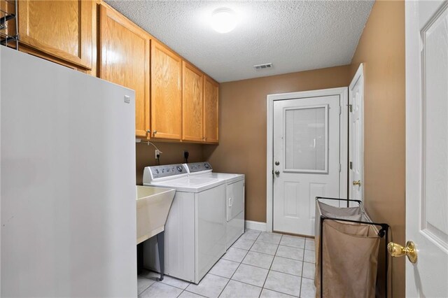 17 P M Hall Rd, Poplarville, MS 39470 - laundry area with washer and clothes dryer, sink, cabinets, a textured ceiling, and light tile patterned floors