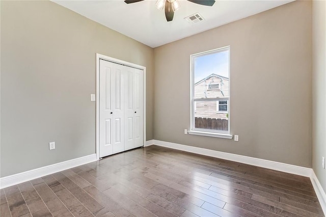 unfurnished bedroom with wood-type flooring, multiple windows, a closet, and ceiling fan