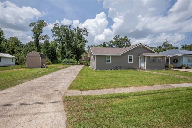 ranch-style house featuring a front lawn and a storage shed