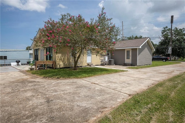 view of front of house with a front lawn and cooling unit