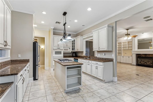 kitchen with white cabinets, stainless steel appliances, a center island, and light tile patterned floors