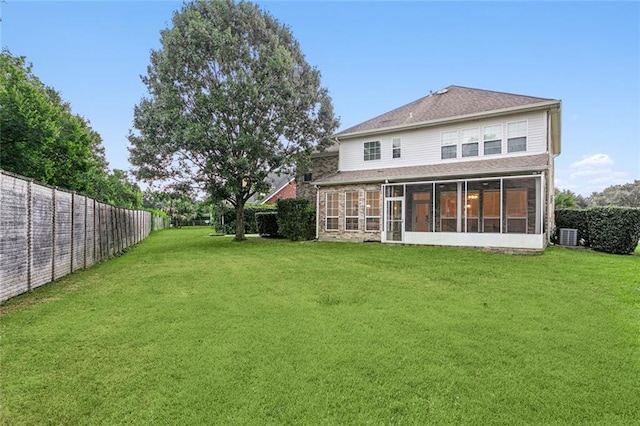 rear view of property featuring a yard and a sunroom