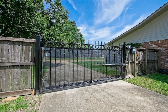 view of gate with a yard