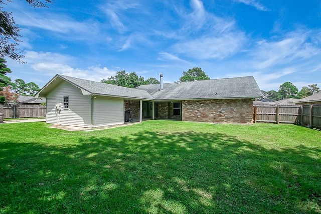 rear view of property with a lawn