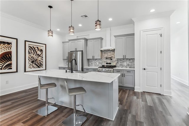 kitchen featuring tasteful backsplash, dark wood-type flooring, stainless steel appliances, light stone countertops, and a center island with sink