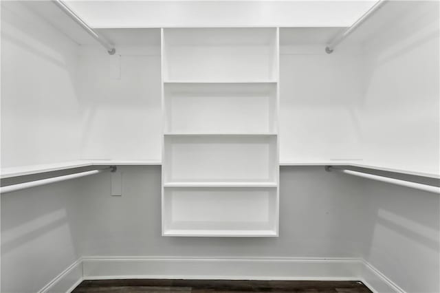 walk in closet with dark wood-type flooring