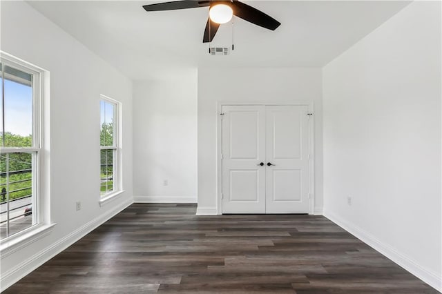 unfurnished bedroom featuring dark hardwood / wood-style floors, a closet, and ceiling fan