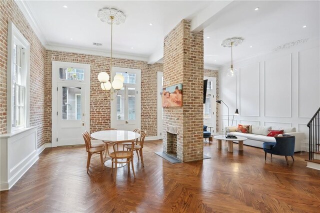 810 Bourbon St, New Orleans, LA 70116 - dining room featuring a decorative wall, a fireplace, brick wall, crown molding, and stairway