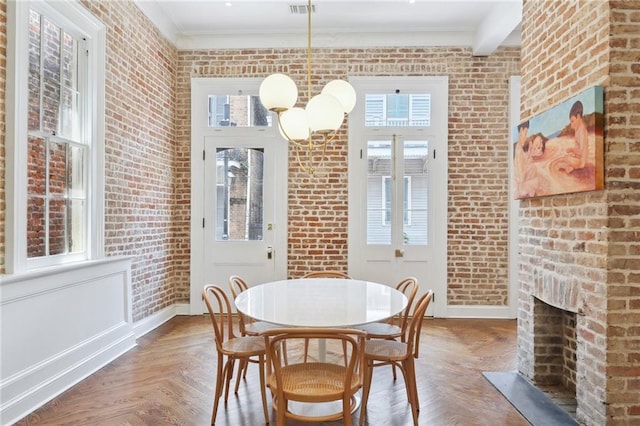 810 Bourbon St, New Orleans, LA 70116 - dining area featuring brick wall, baseboards, a brick fireplace, and ornamental molding