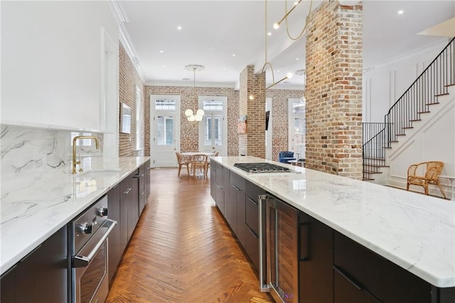 810 Bourbon St, New Orleans, LA 70116 - kitchen with wine cooler, modern cabinets, stainless steel appliances, brick wall, and a sink