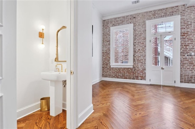 810 Bourbon St, New Orleans, LA 70116 - foyer with baseboards, brick wall, and ornamental molding