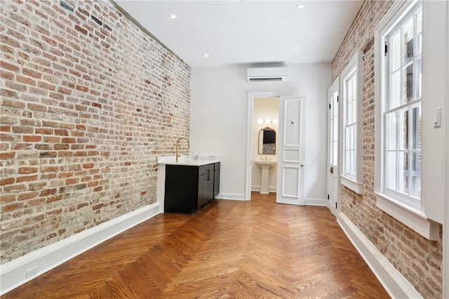 810 Bourbon St, New Orleans, LA 70116 - corridor featuring a wall mounted AC, baseboards, brick wall, a sink, and recessed lighting