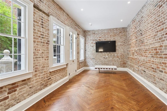 810 Bourbon St, New Orleans, LA 70116 - unfurnished living room featuring brick wall, baseboards, and recessed lighting