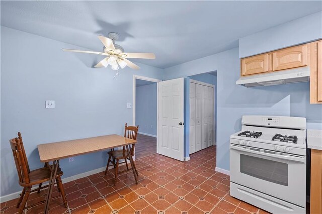 kitchen with ceiling fan, light brown cabinets, and gas range gas stove