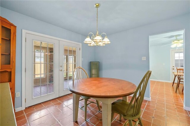 dining room featuring plenty of natural light, tile patterned flooring, ceiling fan with notable chandelier, and french doors