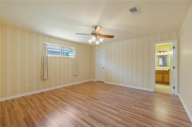 empty room with ceiling fan and light hardwood / wood-style floors