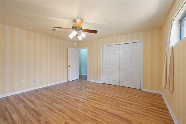 unfurnished bedroom with ceiling fan, a closet, and light wood-type flooring